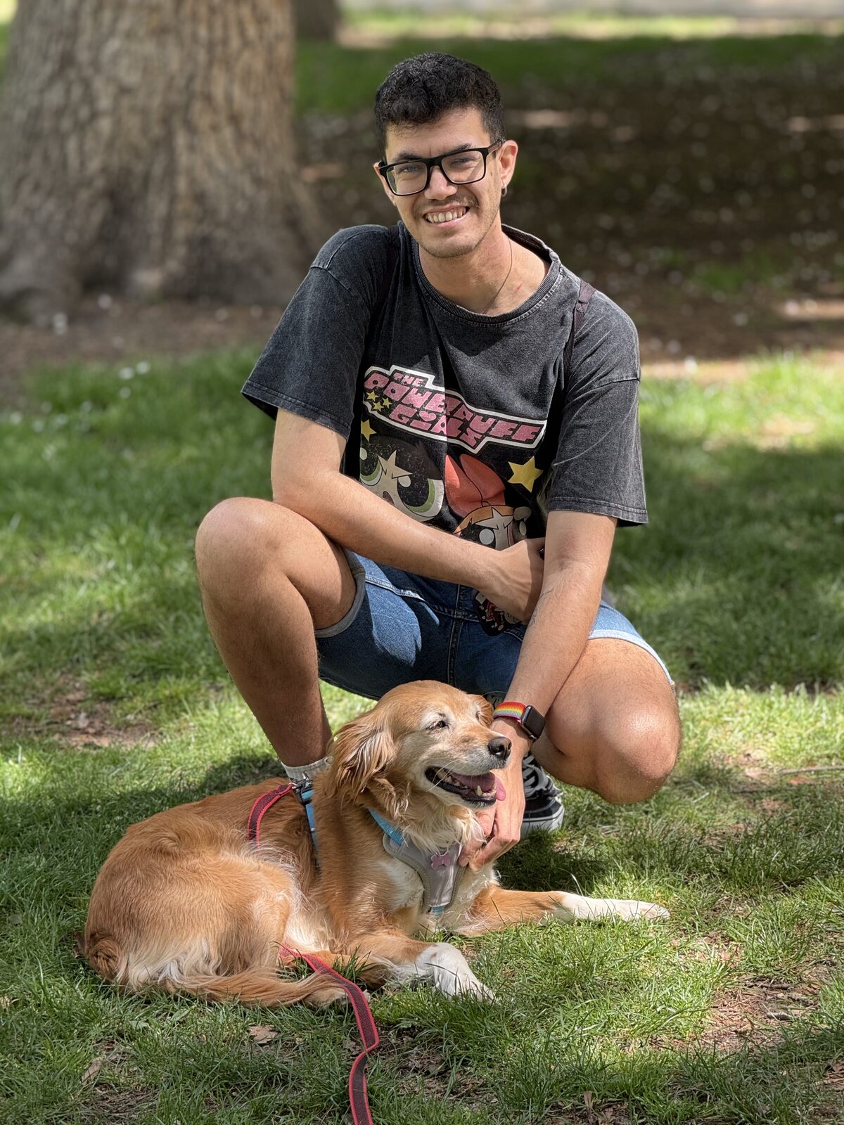 Ian agachado en un parque junto a Sunny, tumbada en el césped